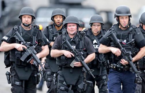 Heavily armed police move through residential streets in Watertown, Mass.