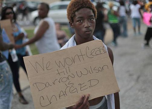 A protester in Ferguson calls for Mike Brown's murderer to be arrested