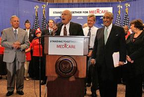 Rep. John Dingell speaks, surrounded by fellow Democrats, after George Bush's veto of Medicare legislation was overridden by Congress