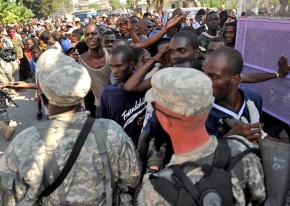 U.S. soldiers hold back a large gathering of displaced people waiting for aid in Port-au-Prince