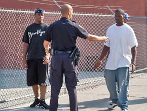A New York police officer stops young men in Brooklyn