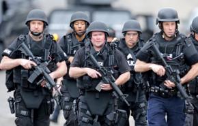 Heavily armed police move through residential streets in Watertown, Mass.