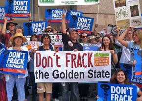 Filmmaker Josh Fox (center with hand raised) joins activists at a conference of activists