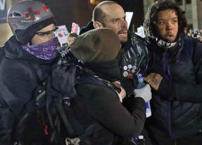 A wounded protester is helped away from a demonstration against far-right speaker Milo Yiannopoulos